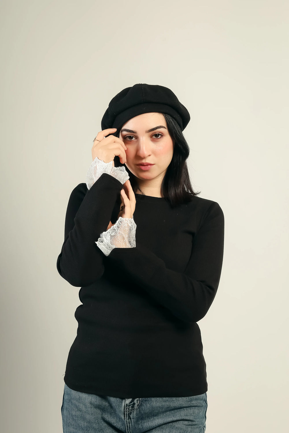 Gumus lace cuff ribbed top in black, worn with jeans and a beret — front view