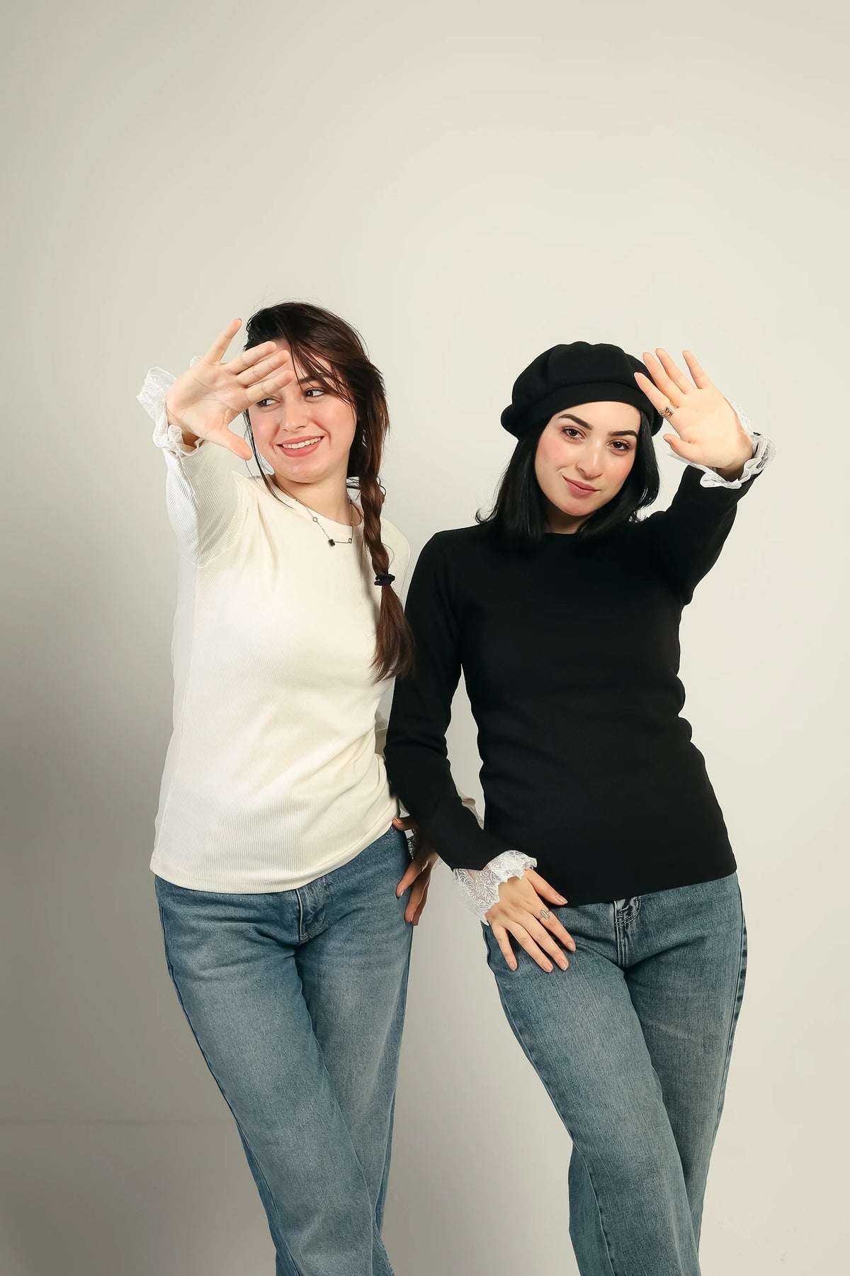 Two models wearing the Gumus lace cuff ribbed top in offwhite and black