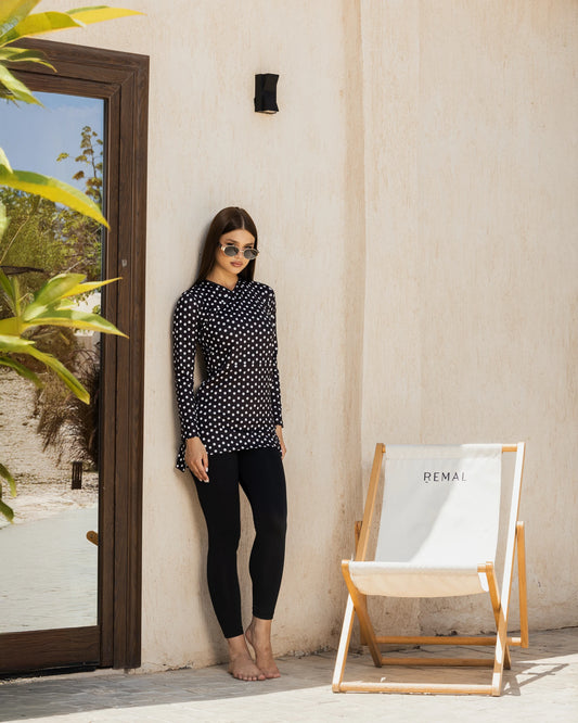 Woman in black polka dot modest swimsuit tunic