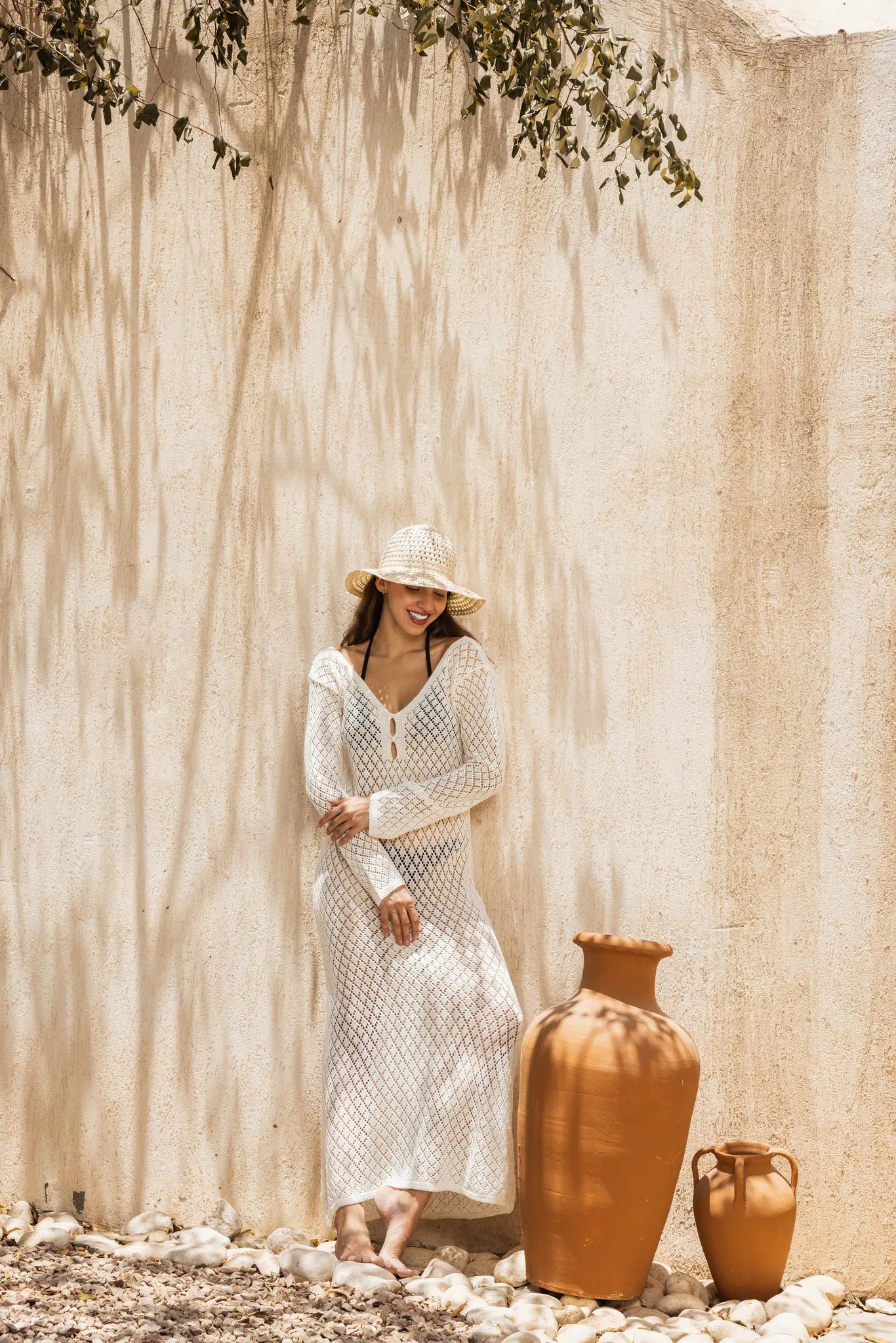 Ivory open-knit crochet beach dress leaning on wall