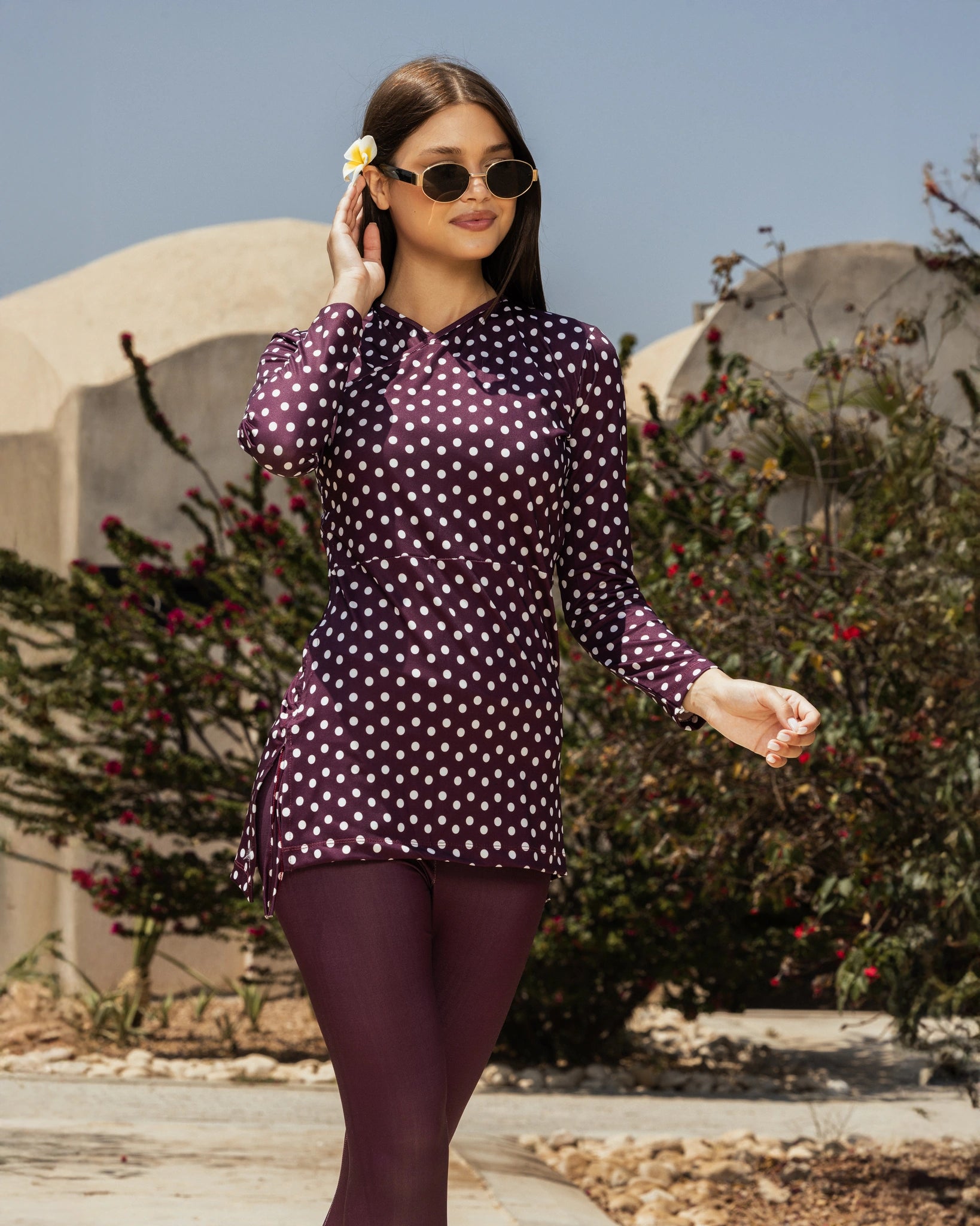 Woman in plum polka dot modest swimsuit tunic